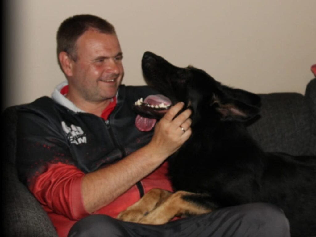 Jagger playing happily with handler Raymond, showing a positive and relationship-based training philosophy built on trust and joy.
